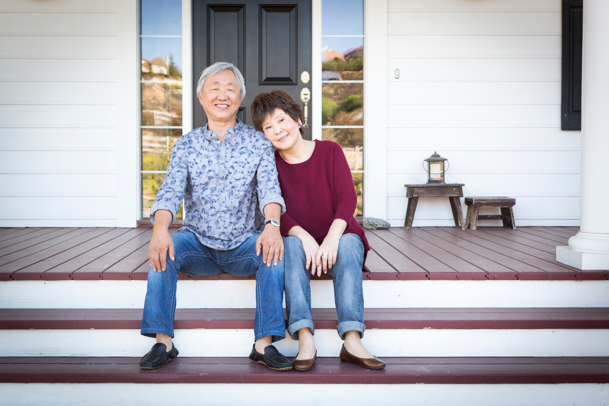 Senior Chinese Couple Sitting on Front Steps of Their House